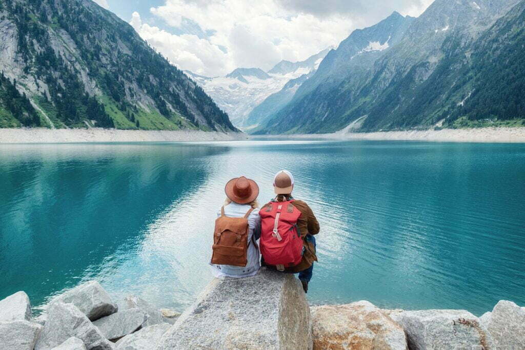 couple sitting in front of beautiful lake with travels insurance