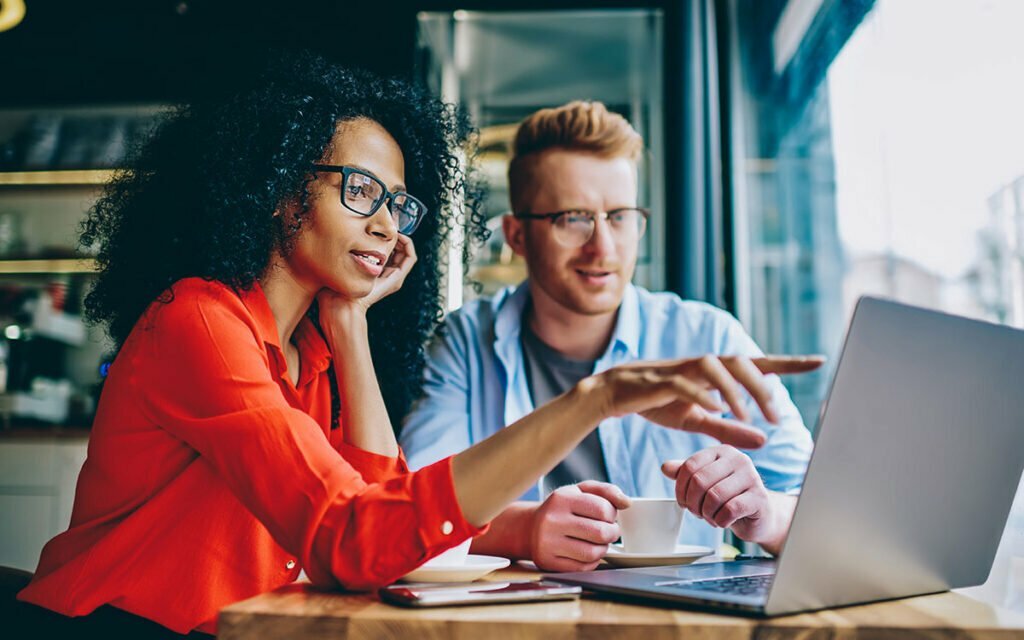two coworkers working on a laptop